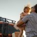 A joyful moment between a father and daughter outdoors with a van in the background.